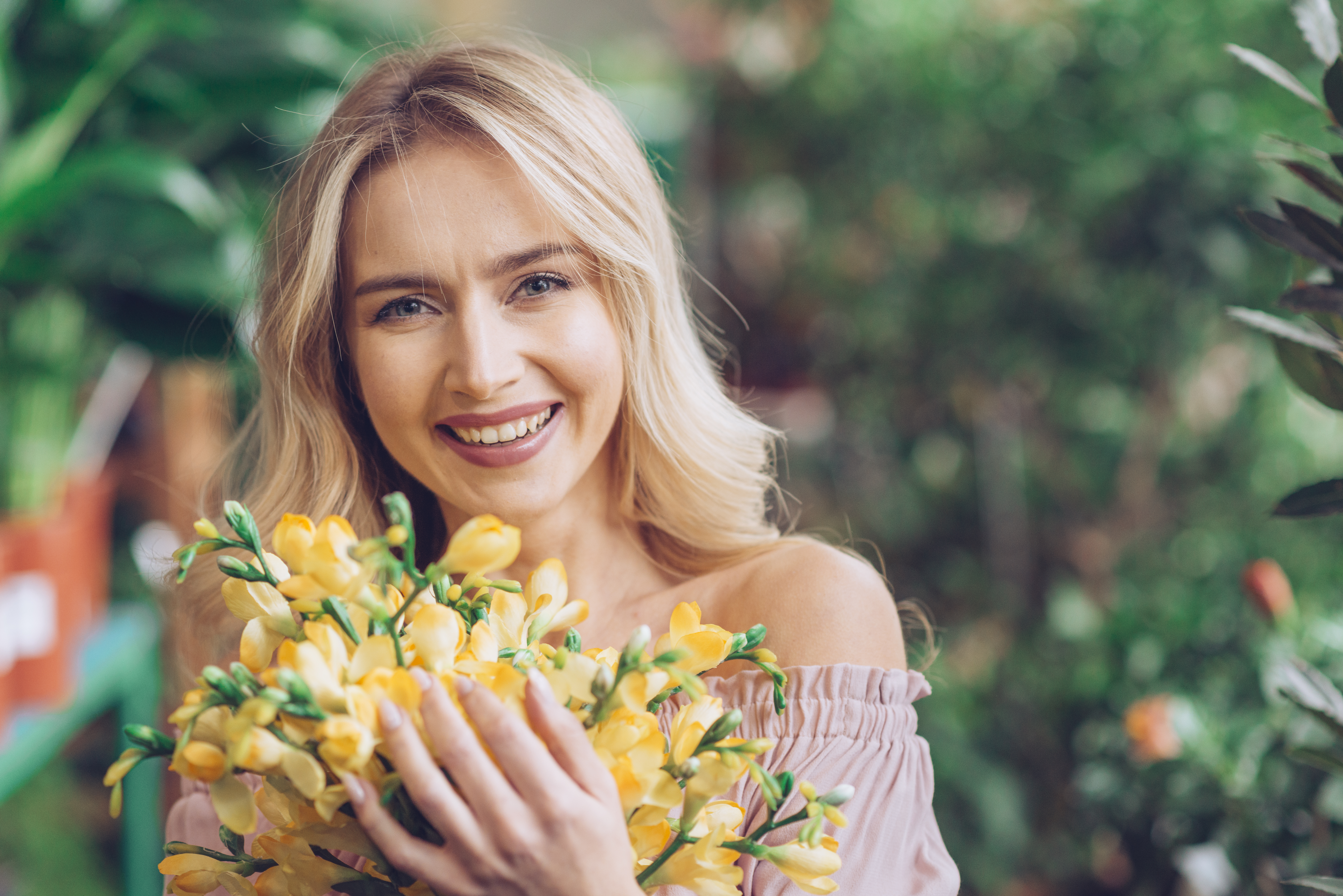 happy woman standing with yellow flowers bouquet